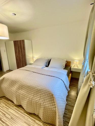 a bedroom with a large bed with white sheets and pillows at PHENIX Alpin Apartment Kreischberg in Murau