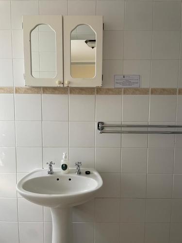 a bathroom with a sink and a mirror at 137 High Street Guest House in Grahamstown