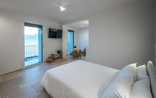 a bedroom with a white bed and a balcony at Trame Suites in San Vito Chietino