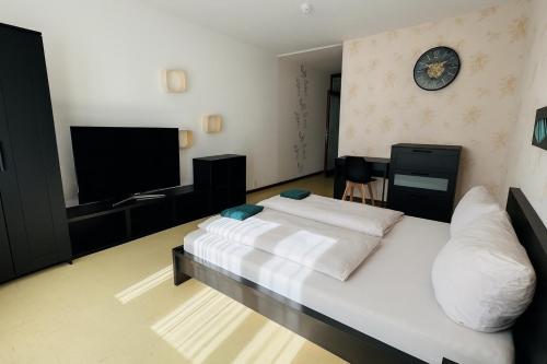 a bedroom with a bed and a clock on the wall at Helle 2-Zimmer Erdgeschosswohnung mit Terrasse in Koblenz