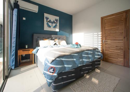 a bedroom with a bed with a blue wall at Ocean Blue Villa, Flic-en-Flac in Flic-en-Flac