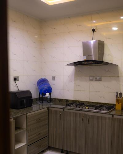 a kitchen with a sink and a stove top oven at The Cedar Room, Cozy 2bed, Unlimited Wi-fi, Lekki Phase1 in Lagos