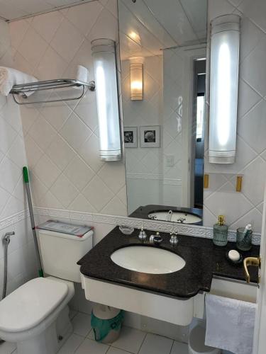 a bathroom with a toilet and a sink and a mirror at Hotel UH2107 Inter Jardins in Sao Paulo