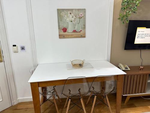 a table with two chairs and a white counter top at Hotel UH2107 Inter Jardins in Sao Paulo