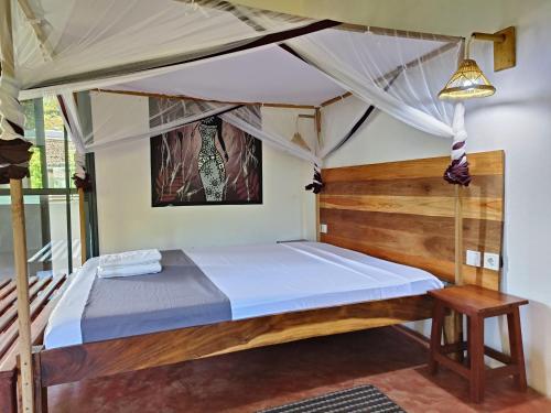 a bedroom with a bed with a canopy at Auberge SAKATI'Art in Nosy Be