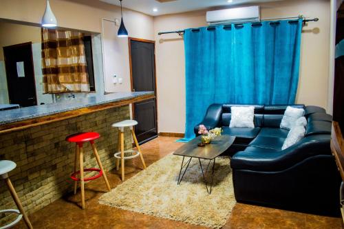 a living room with a black couch and a bar at Kurhulla Guest House in Chimoio