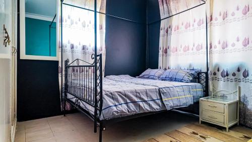 a bedroom with a canopy bed with blue walls at Goshen Grove in Kampala