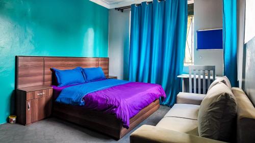 a bedroom with a bed and a couch at Goshen Grove in Kampala