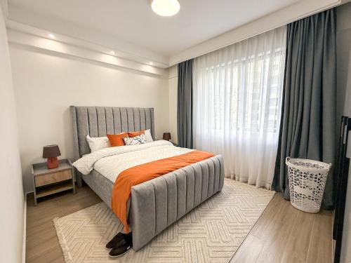 Un dormitorio con una cama con una manta naranja. en Azalea Homes - Winchester gardens, en Nairobi