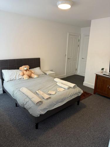 a bedroom with a bed with a teddy bear on it at Cozy 2-Bed Apartment - Central Luton Location in Luton