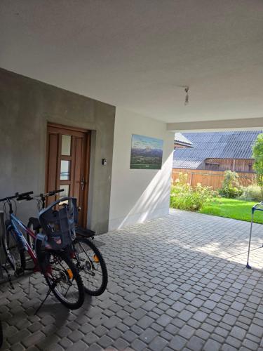 a bike parked next to a building with a door at Noclegi nad Czarną Orawą in Podwilk