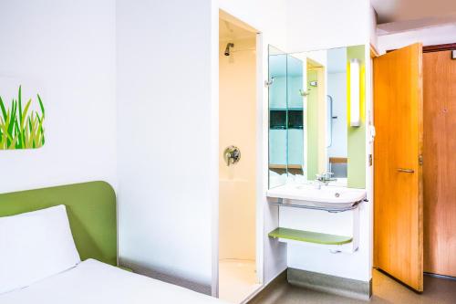 
a bathroom with a bed and a shower at ibis budget Southampton Centre in Southampton

