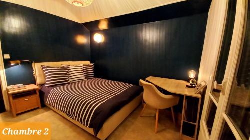 a small bedroom with a bed and a table at Chambres dans une maison de charme au calme en bord de Marne proche transports in Joinville-le-Pont