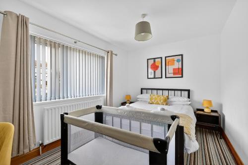 sypialnia z łóżkiem i oknem w obiekcie StayByNumbers - Spacious three bed house Royal Hillsborough w mieście Hillsborough