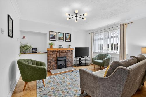 a living room with two chairs and a fireplace at Hillsborough Home from Home, Garden and 2x Parking by StayByNumbers in Hillsborough