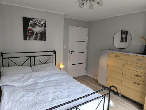 a bedroom with a bed and a mirror and a dresser at Belle Apartament in Krapkowice