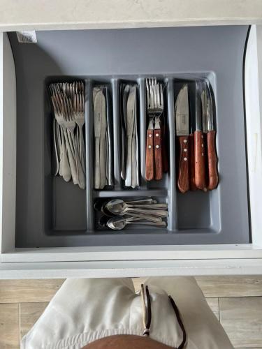 a drawer filled with utensils in a cabinet at Mar Bela Suites in Ubomo