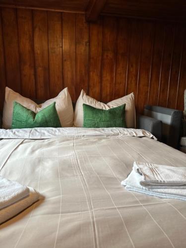a large bed with green and white pillows on it at NEU! Seepanorama, am See 15 min von Interlaken in Oberried