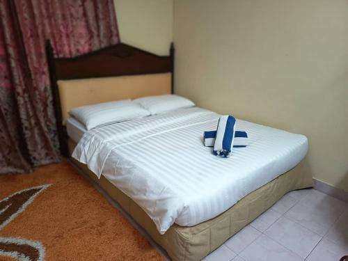 a bed with a blue backpack on top of it at Homestay Haji Hamid in Pantai Cenang