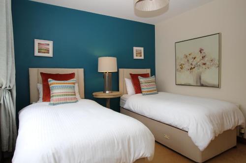 two beds in a room with blue walls at Lurgan House in Westport