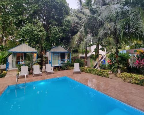 a pool at a resort with chairs and palm trees at Zensus Eco Boutique Hotel in Bacalar