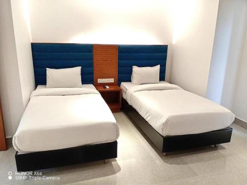 two beds in a small room with two bedsvisor at La Vista Hotel in Sylhet