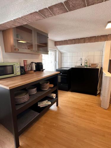 a kitchen with a microwave and a counter with plates at NEU! Seepanorama, am See 15 min von Interlaken in Oberried