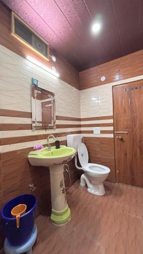 a bathroom with a sink and a toilet at Sunshine Home Kasauli Hills in Kasauli