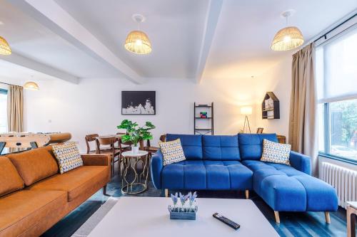 a living room with blue couches and a table at Stunning 3BR Townhouse, Terrace, Games, Free Parking in Manchester