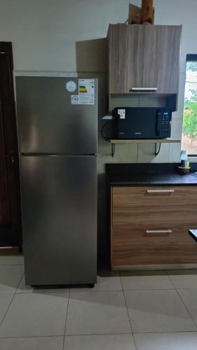 a kitchen with a stainless steel refrigerator and a microwave at Lovely Home Near the Airport and Business District in Luque