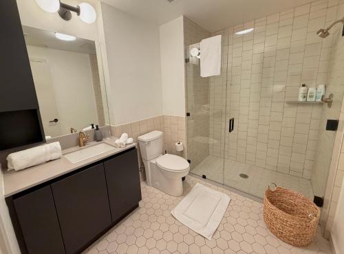 Un baño con inodoro, lavabo y ducha. en Hollywood Walk of Fame I Pool View I Fitness Center I Free Parking!, en Los Ángeles