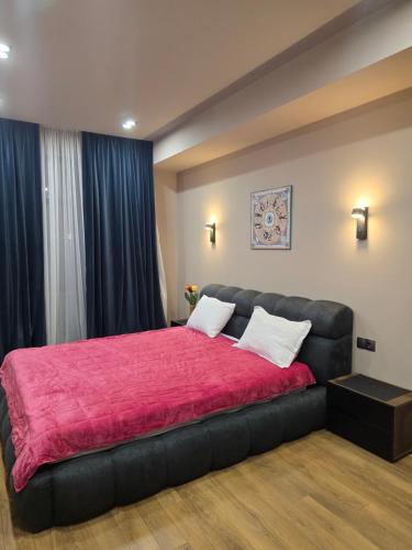 a bedroom with a large bed with a red blanket at Green House Mindeli in Tbilisi City