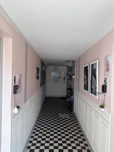 a hallway with a black and white checkered floor at Étape du faubourg I Orléans I Proche Gare in Orléans