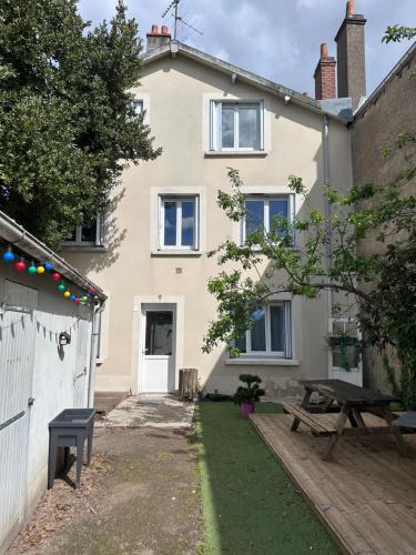 a house with a picnic table in front of it at Étape du faubourg I Orléans I Proche Gare in Orléans