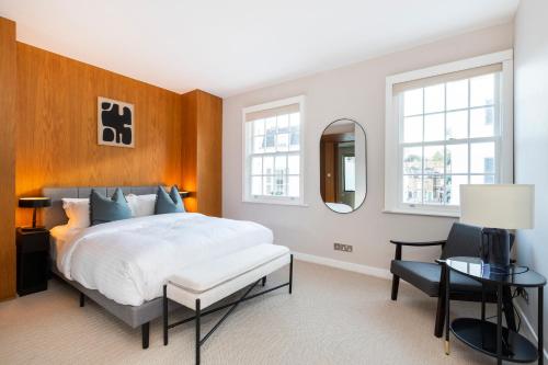 a bedroom with a bed and a table and a mirror at Elegant 3 bd house in Knightsbridge in London