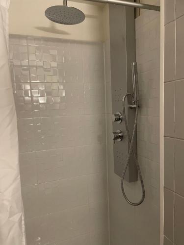 a shower with a shower head in a bathroom at Étape du faubourg I Orléans I Proche Gare in Orléans