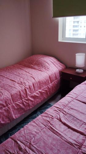 a bedroom with two beds and a table and a window at Vista hermosa in Algarrobo