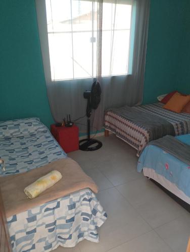 una stanza con due letti e una finestra di casas em búzios 8 a Búzios