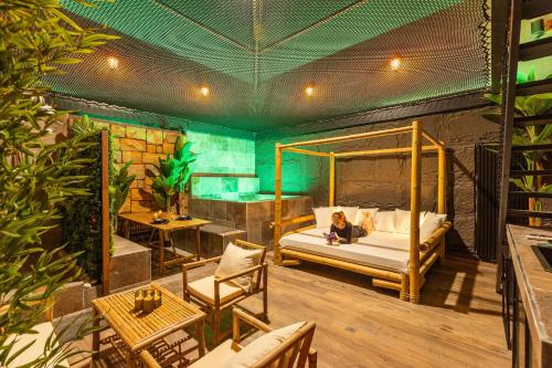 a woman sitting on a bed in a room at Intense Experience - Suites wellness avec piscine jacuzzi sauna billard privatifs in Manage