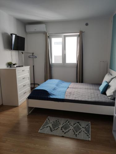 a bedroom with a bed and a window and a dresser at Villa Dobra Holiday Apartments in Vir
