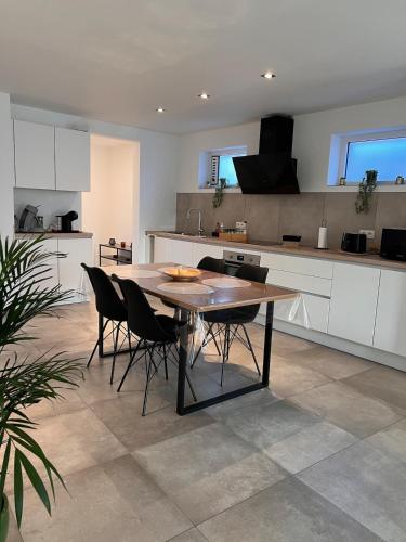 a kitchen with a wooden table and chairs at La Bouverie in Profondeville