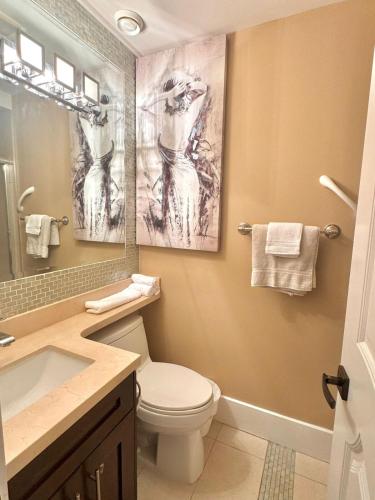 a bathroom with a toilet and a sink and a mirror at Cozy 1 Bedroom Suite in Vancouver