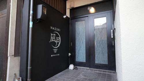 a black door with a sign on the side of a building at Nagatsuki - Vacation STAY 19182 in Fukuyama