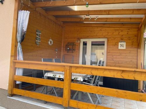 a front porch of a wooden house with a wooden railing at Két szobás, teraszos, kertes vendégház in Balatonmáriafürdő