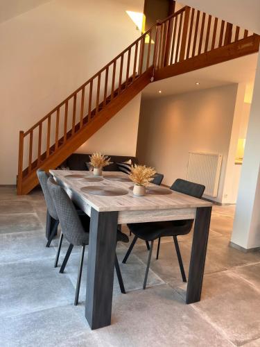 a dining room table with chairs and a staircase at Maison Lesve in Profondeville
