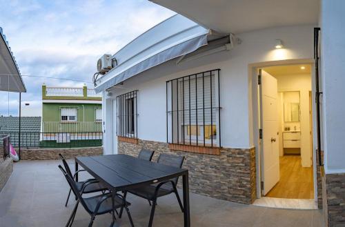 a table and chairs on a patio with a house at Pedrega Beach in Málaga