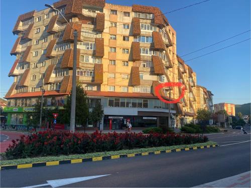 a tall building with a red sign on the side of it at Central Home in Piatra Neamţ
