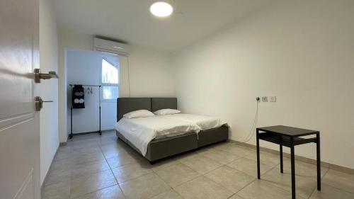 a bedroom with a bed and a table in it at Tiberias CITY HOUSe in Tiberias