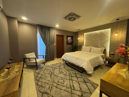 a bedroom with a bed and a table and a chair at Kazani Heights Luxurious apartments in Islamabad