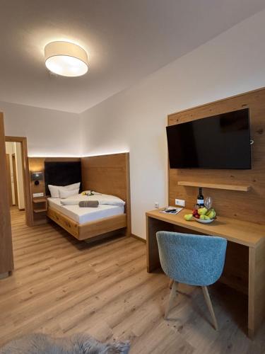 a bedroom with a bed and a desk with a television at Gasthaus Kerber in Fürstenstein